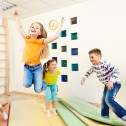 Kinder hüpfen fröhlich im Gymnastikraum herum